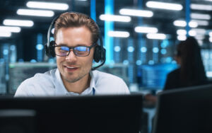 Information Technology expert examining the data available on a computer monitor while talking with a client.