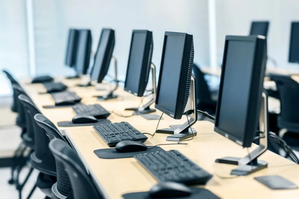 A bank of computers sits at an office ready to work after managed IT has been performed.