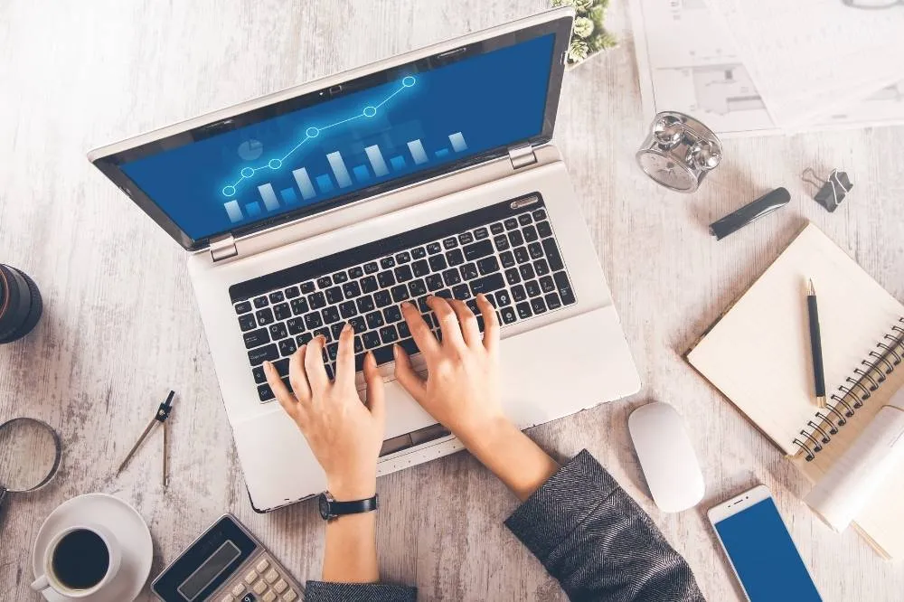A managed IT expert works on a laptop computer to help a client.