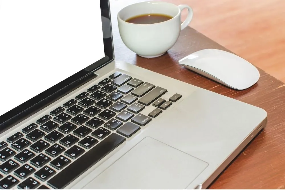 A managed IT expert sits at a client's workstation with a coffee cup ready to go.